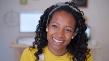 Mutlu siyah kız kameraya bakıp gülümsüyor. Memleketteki neşeli Afrikalı kadın portresi. Dairedeki insanlar.. 