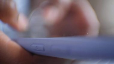 Odaklanmış ve gün boyunca cep telefonunu kullanan tanınmayan genç siyahi kadın parmaklarına odaklanmış. Mobil ekranda yazan ve sosyal ağlara bakan insanlar.