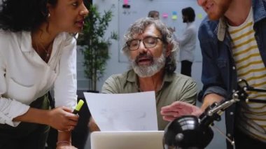 Modern ofis çeşitli iş arkadaşları erkek kıdemli liderle konuşarak iş stratejileri geliştirmek için toplantılar yapıyorlar. İş arkadaşları patronla konuşuyor. İnsanlar işlerini geliştirmek için fikirlerini paylaşıyorlar..