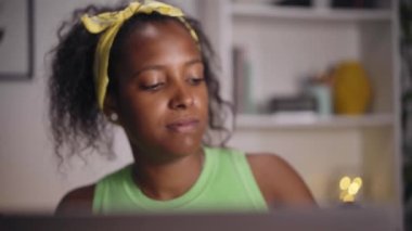 Ofisinde dizüstü bilgisayar kullanan gülümseyen genç Amerikalı kadının videosu. Mutlu kız cep telefonundan sesli mesaj gönderiyor. Online randevu uygulaması kavramı. 