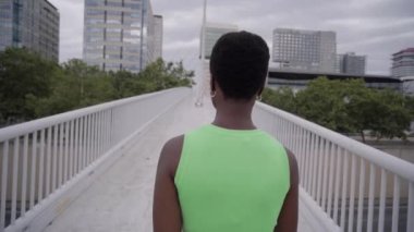 Güzel Afro-Amerikan kadın tek başına yürüyor ve kameraya ciddi ciddi bakıyor. Doğal etkiye sahip biri. Z jenerasyonu ve bin yıllık portre konsepti. Gençler ve sosyal medya. 