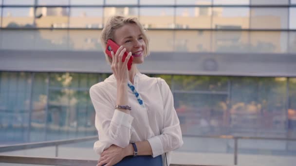微笑的中年金发白人女人在工作场所外的手机上发送语音讯息 律师接听城市街道上的一个电话 专业商人 — 图库视频影像