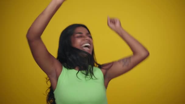 Mulher Sorrindo Pulando Entusiasmadamente Celebrando Uma Vitória Estúdio Fundo Amarelo — Vídeo de Stock