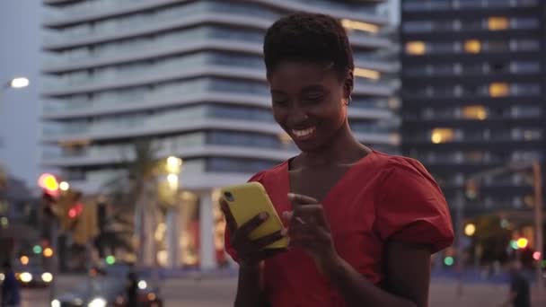 Улыбающаяся Чернокожая Женщина Стоящая Улице Серфингистка Мобильным Телефоном Молодые Люди — стоковое видео