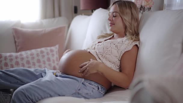 Feliz Relajada Madre Embarazada Joven Tocando Vientre Sentado Sofá Casa — Vídeo de stock