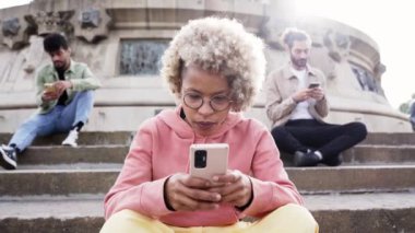 Bir grup insan ciddi suratlı telefonları kullanarak birbirlerini görmezden geliyor. Latin bir kadın cep telefonuna odaklanmış. Yüksek kalite fotoğraf