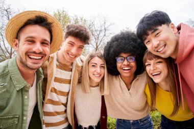 Büyük bir grup neşeli genç arkadaş selfie portresi çekiyorlar. Mutlu insanlar birbirine sarılıyor ve kameraya bakıp gülümsüyor. Toplum kavramı, gençlik yaşam tarzı ve sonbaharda arkadaşlık . 