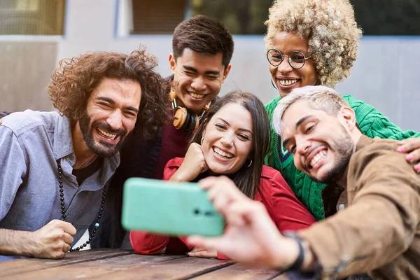 幸せな多人種間の友人が自分撮りを楽しんでいる 一緒にスマートフォンを使用して若い幸せな人々 高品質の写真 — ストック写真