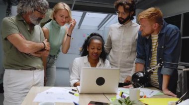 Çeşitli iş adamları ofis konferans odasında toplandı. Kadın liderin etrafında yaratıcı bir grup. Meslektaşlar pazarlama kampanyası, sosyal medya stratejisi hakkında konuşur. İnsanlar modern işyeri