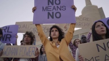 Protesto eden bir grup insan eylemcisi. Feminizm Gösterisinde kameraya bakan bir kadın. Yüksek kaliteli FullHD görüntüler