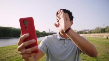 Dışarıda video sohbetinden hoşlanan mutlu adam. Günlük kıyafetli genç adam görüntülü konuşma yapıyor. Yüksek kalite 4k görüntü