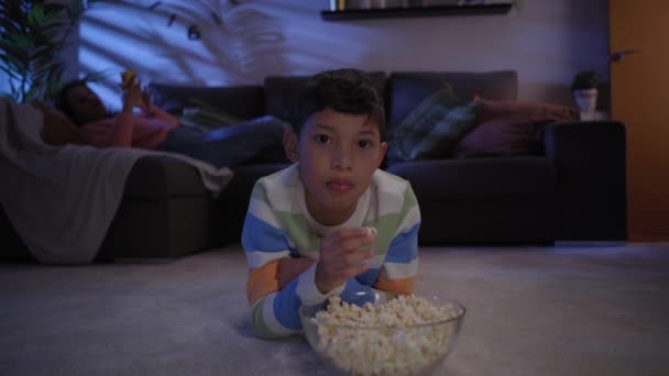 Uśmiechnięty Latynoski Chłopiec Oglądający Kreskówki Telewizji Leżący Nocą Dywanie Salonie — Wideo stockowe