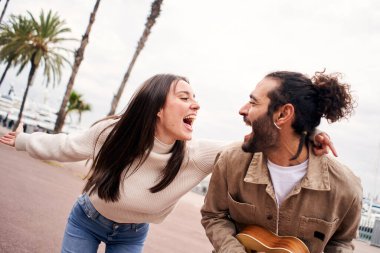 Mutlu çift dışarıda şarkı söylerken eğleniyor. Yüksek kalite fotoğraf