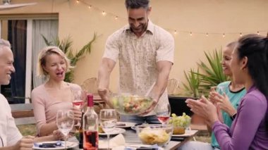 Olgun bir adam arka bahçedeki bir toplantıda arkadaşlarına masayı servis ediyor. Özel bir yaz partisinde iş arkadaşlarını eğlendirmek. Aileyle boş zaman ve zevk anları..