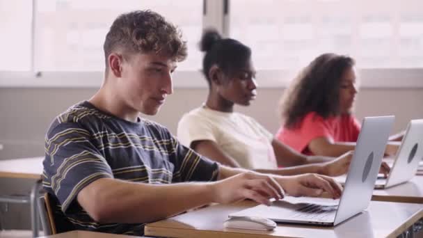由三名年轻中学生组成的多族裔群体使用计算机共同学习 数字化的教育和技术 专注于在笔记本电脑上打字的男孩 一代又一代 — 图库视频影像