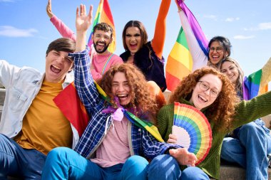Farklı heyecanlı genç arkadaş grubu eşcinseller festivalini birlikte kutluyor. Neşeli insanlar LGBT topluluğu dışarıdaki kameralara bakarak komik poz veriyor. Lezbiyen, gey, transseksüel ve ikili olmayan.