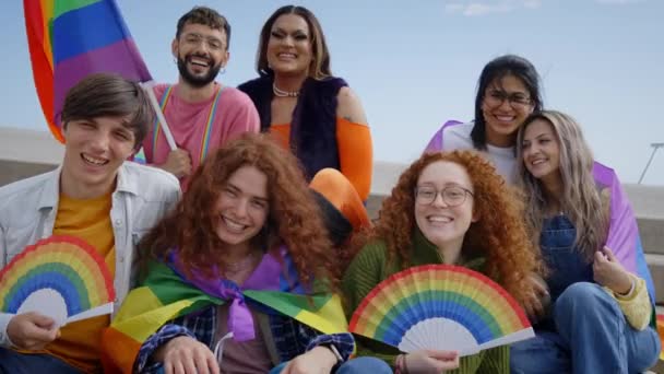 ゲイのプライドフェスティバルの日を一緒に祝う別の興奮した若い友人グループ 楽しい人Lgbtコミュニティは屋外でカメラを見て面白いポーズをとります レズビアン トランスジェンダー ノンバイナリ — ストック動画