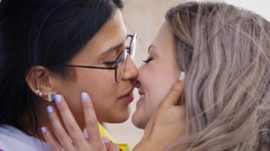 Eşcinsel onur festivali gününde genç lezbiyen kadınlar öpüşüyor. Aynı cinsiyet seven ilişkiler insanlar. Z nesli ve homoseksüellik. 