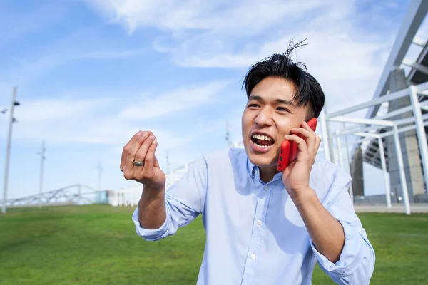 Vred Ung Asiatisk Mand Der Taler Mobiltelefon Irriteret Kinesisk Dreng - Stock-foto