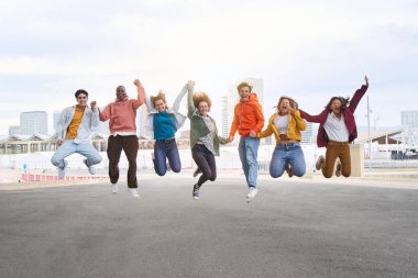 Bir grup farklı genç birlikte özgürlüğün tadını çıkarıyor. Heyecanlı çok kültürlü arkadaşlar şehir caddesinde el ele tutuşuyorlar. Kadın ve erkeklerin kollarını gökyüzüne kaldırdıkları mutluluk kavramı.. 