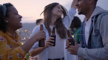 Çatıdaki barbekü partisinde dans eden mutlu genç grup arkadaşları. Heyecanlı insanlar atlıyor. Akşamları barbeküde bira içerek eğleniyorlar. Öğrenciler yaz tatilini kutluyor.