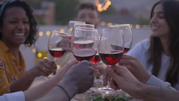 와인으로 건배하고 테라스에서 파티를 축하하는 즐거운 친구들의 사람들은 옥외에서 알코올 — 비디오