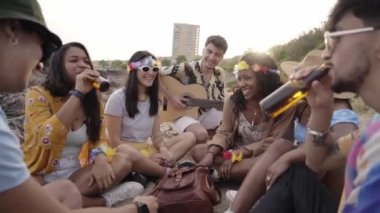 Bir grup arkadaş gün batımında sahilde eğleniyor ve içki içiyor. Gençler açık hava partisini gitar müziğiyle kutluyor. İnsanlar birayla kadeh kaldırıyor ve sohbet ediyorlar.. 