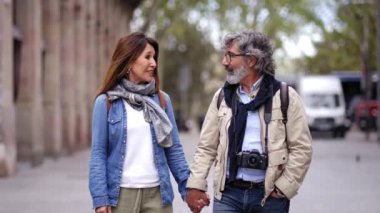 Gülümseyen yaşlı bir çift şehirde sohbet ederek ve el ele tutuşarak eğleniyor. Emekliler birlikte sokak turunun tadını çıkarıyorlar. Olgun evlilik ilişkisi ve emeklilik tatili.