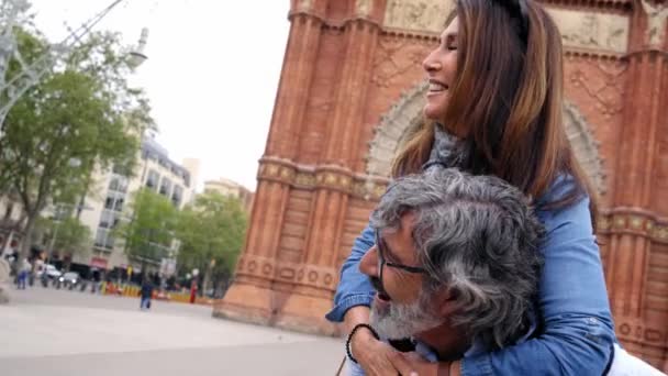 一緒に休暇を楽しんでいる高齢者のカップルを笑顔 ヨーロッパの都市を訪れる余暇を楽しむ高齢者のピギーバック成熟した女性 定年退職における恋愛関係者の概念 — ストック動画