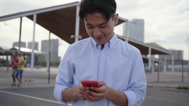 Asiatisk Pojke Skrattar Stadens Gata Chatta Med Smart Telefon Kinesiska — Stockvideo