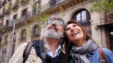 Emekli bir çiftin mutlu ve açık havada gülümsediği videoyu kapat. Sevecen bir şekilde olgun romantik evlilikleri kucaklıyor. Emeklilik tatillerinde sokakta turistik bir şeyler izliyorlar.. 