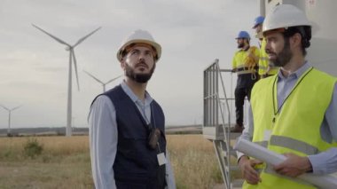 Kafkas mühendisleri bir rüzgar türbinleri çiftliğinde anlaşmaya varmayı tartışıyorlar. Yenilenebilir enerji teknolojisi ve sürdürülebilirlik için yeni projeler başlatın. Gelecek için alternatif çözümler.