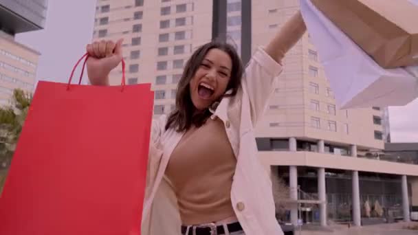 Film Podekscytowaną Młodą Kobietą Zakupoholiczką Trzymającą Papierowe Torby Zakupami Uśmiechniętą — Wideo stockowe