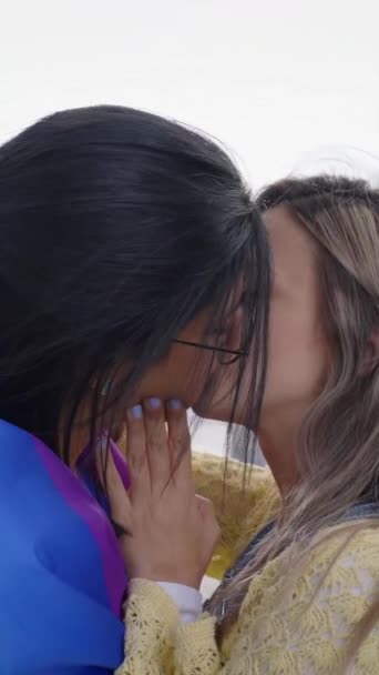 垂直的 两个年轻可爱的女孩在户外的同志骄傲节亲吻 一群朋友在彩虹旗和歌迷的背景下庆祝Lgbt派对 Z代和性行为类型 — 图库视频影像