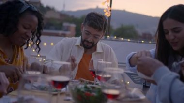 Bir grup mutlu arkadaş çatı katındaki barbekü toplantısında sohbet ediyorlar. Gençler akşam birlikte dışarıda terasta akşam yemeği yiyorlar. Erkekler ve kadınlar yaz günü masada sosyalleşiyorlar. Arkadaşlık ilişkileri.