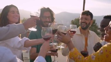 Çok ırklı insanların toplanıp çatı partisini kutlamaları gün batımında kırmızı şarapla kadeh kaldırmaları. Bir grup genç arkadaş yaz günü terasta gülerek eğleniyor. Bin yıllık sosyalleşme ve şenlik.. 