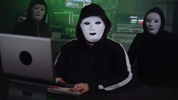 Drie Gemaskerde Hackers Zitten Een Donkere Kamer Met Neonlichten Man — Stockvideo