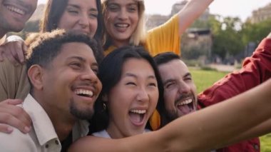 Dışarıdaki çok ırklı arkadaşların portresi. Bir grup değişik, komik suratlı genç insan selfie çekimi için birlikte poz veriyor. Mutlu insanlar toplum içinde arkadaşlığın tadını çıkarıyorlar. Sosyal ilişkiler