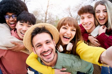 Bir grup çok ırklı öğrencinin selfie 'si ve kameraya bakarken çokça gülmeleri. Birbirlerine sarılırken mutlu ve arkadaş canlısı görünüyorlar. Portre.