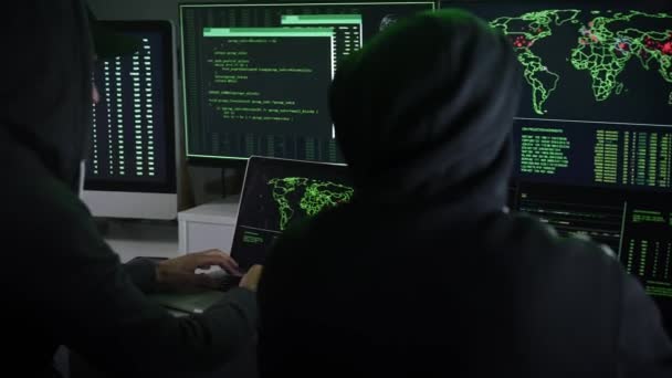 Zwei Vermummte Hacker Arbeiten Zusammen Und Zeigen Auf Displays Einem — Stockvideo