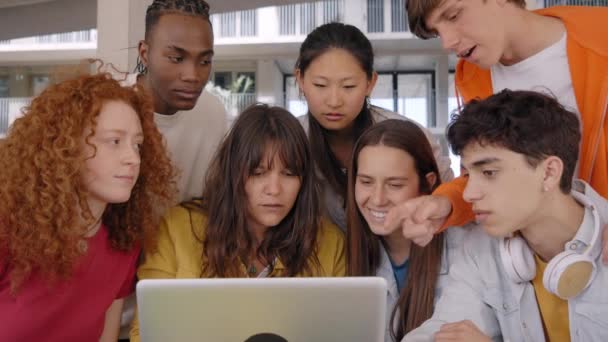 年轻的学生聚集在笔记本电脑前 聚精会神地看着屏幕 一群认真的大学生坐在校园外做课堂工作 社区中的一代青少年 — 图库视频影像