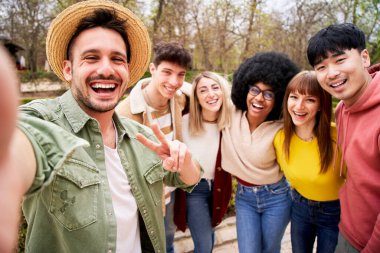 Kameraya bakıp gülen bir grup genç arkadaşın selfie 'si. Kucaklaşan ve ayakta duran çok ırklı öğrencilerin portresi. 