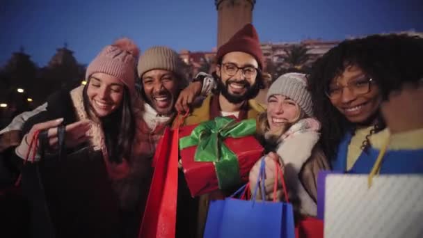 Вечером Улыбающиеся Многорасовые Друзья Показывают Сумки Подарками Камеру Счастливая Юная — стоковое видео