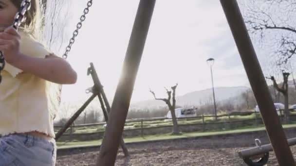 Menina Loira Alegre Olha Para Câmera Feliz Balançando Balanço Parque — Vídeo de Stock