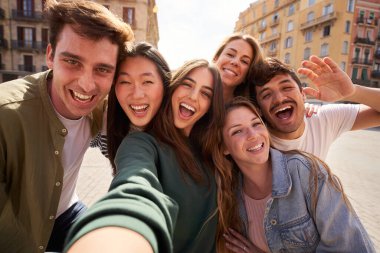 Çok ırklı, güzel arkadaşların açık havada eğlenirken çekilmiş mobil selfie 'si. Mutlu kameraya bakan heyecanlı insanlar güneşli bir günde şehri gezmekten zevk alıyorlar. Z nesli ve tatiller.