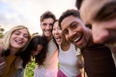 Kucaklaşan bir grup çok ırklı insanın çılgın selfie 'si. Çıkıp boş zamanların tadını çıkaran ve dışarıdaki kameralara bakıp gülen arkadaşlar. Çeşitli erkek ve kızlar topluluğu birlikte kutluyor.