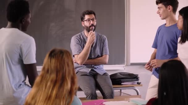 老师帮助他的学生在课后回答他们的问题 男人以非正式的态度坐着与他的受训者交谈 一代人在学习新的概念 — 图库视频影像