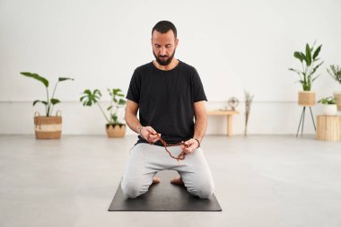 Kafkas yogi adam sakalı meditasyon yapıyor. Orta yaşlı, gözleri kapalı bir erkek sandal ağacı yoga tespihi taşıyor. Erkeksi sağlık, vücut bakımı ve akıl sağlığı kavramı.