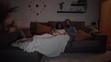 Genç, çok ırklı bir çift, evdeki kanepede uzanıp patlamış mısır yerken gece filmi izleyerek eğleniyor. Oturma odasında battaniyeyi örten iki kişi var. Aşk ilişkileri ve ev hayatı.