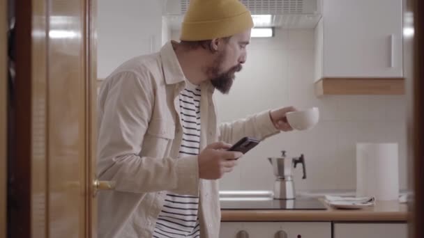 Běloch Usmívá Pije Kávu Nebo Čaj Používá Mobilní Telefon Šťastný — Stock video